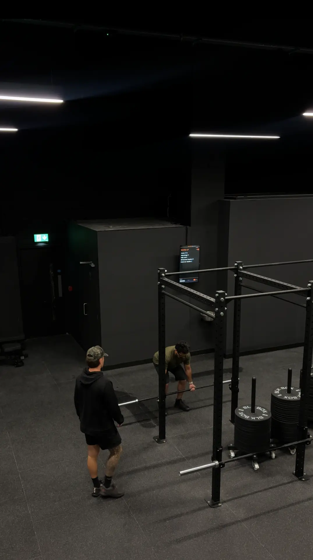 A Nutrifit coach guiding a member through a deadlift